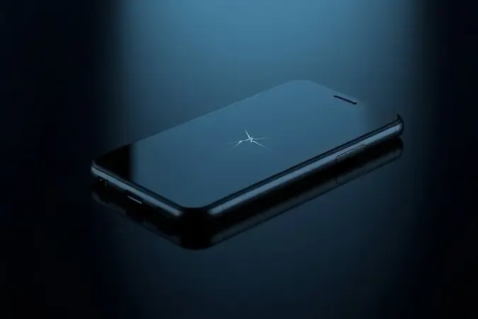 Renderização 3D de smartphone com microfissura sutil no canto da tela sobre superfície escura representando os limites da resistência a quedas.