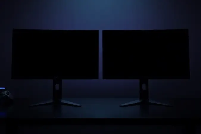Monitores curvo e plano lado a lado em ambiente gamer minimalista com iluminação ambiente suave e reflexos sutis