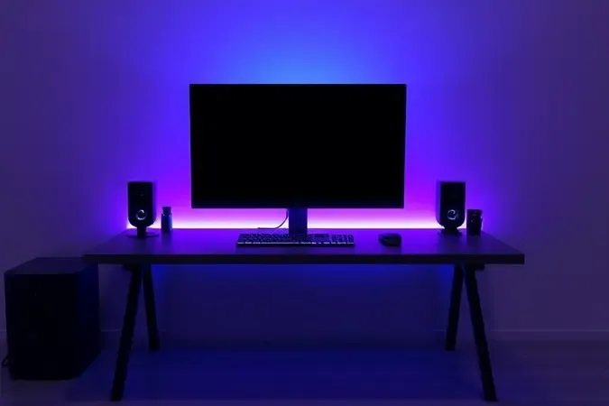 Setup gamer conceitual com monitor moderno e iluminação RGB em renderização 3D profissional.